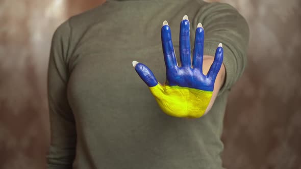 Hand of a Girl With the Flag of Ukraine Asks to Stop the War alt