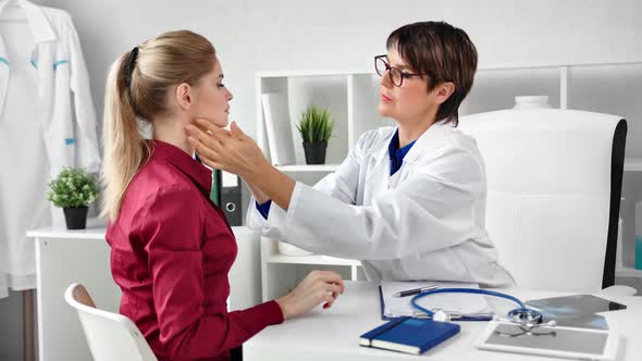 Professional Female Doctor Checking Patient Neck Examining Glands at Modern Clinic White Interior alt