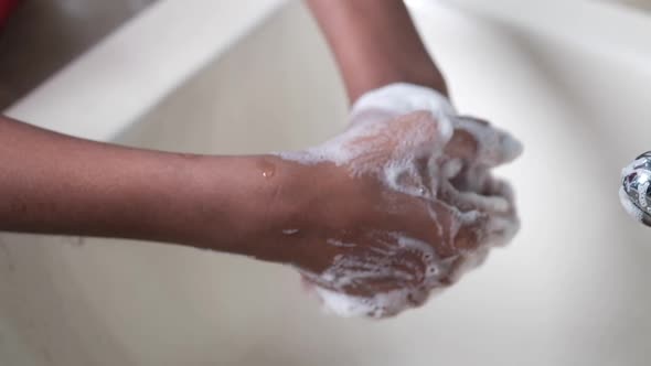 Young Man Washing Hands with Soap Warm Water alt