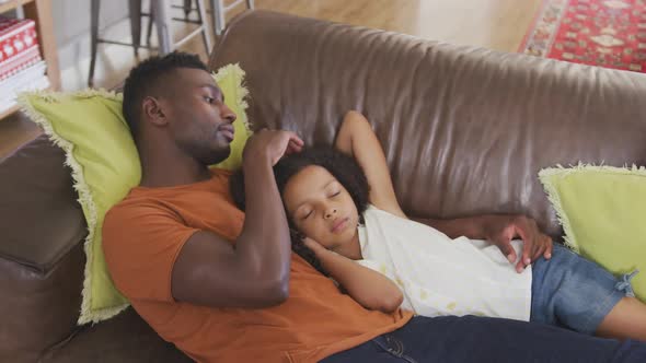 African american father and daughter sleeping in sofa alt