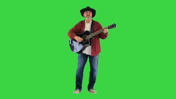 Cowboy Man with Acoustic Guitar Singing a Song on a Green Screen, Chroma Key. alt