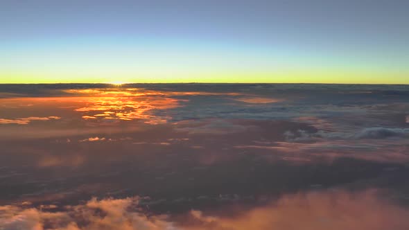 Flying above the clouds; colorful high altitude sunset clouds. Aerial footage.