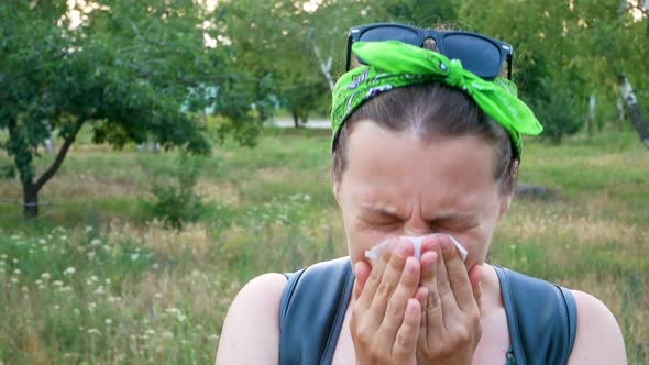 Woman with pollen allergy symptom smelling air with nose Sick girl sneezing blowing in handkerchief alt