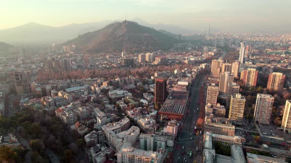 Aerial dolly in of Lastarria neighbourhood buildings, traffic in Alameda avenue and San Cristobal Hi alt