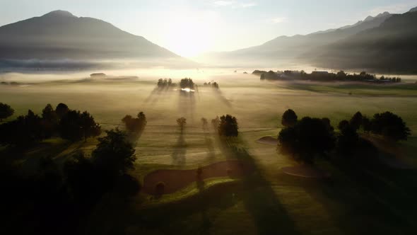 Drone Towards Sunrise Over Misty Landscape Of Zell Am See alt