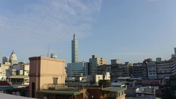 A drone shot of taipei at sunset . The drone is going up in the sky, discovering the further buildin alt