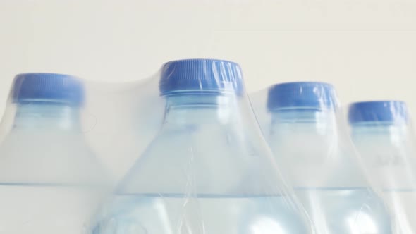 Lot of transparent PET containers with liquid 4K 2160p 30fps UltraHD tilting footage - Package of bo alt