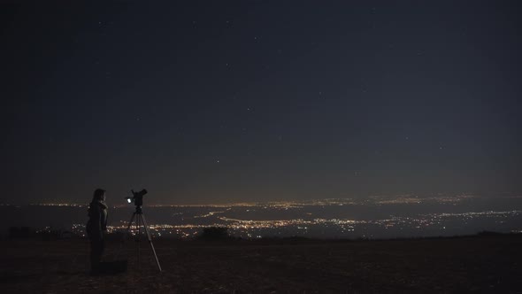 Woman photographing night sky alt