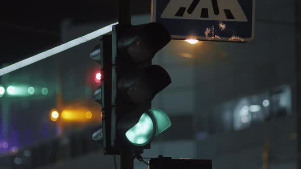 A Traffic Light Is Lit in Green Against the Backdrop of a Modern Building. Evening City.