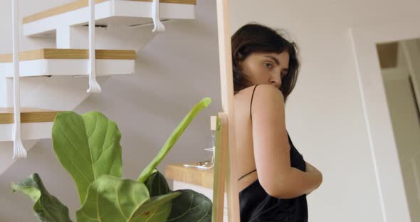 Woman With Short Hair Trying On A Black Evening Dress With Open Back alt