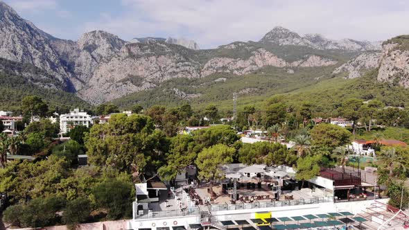 Aerial View of a Resort Town on a Mountain Coast with Beautiful Houses and Hotels and a Recreation alt