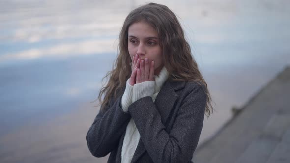 Live Camera Zoom in to Stressed Desperate Young Woman Holding Head in Hands Standing on Urban alt