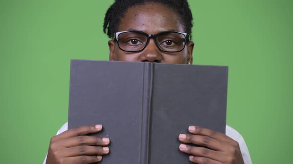 Young Beautiful African Businesswoman Covering Face with Book