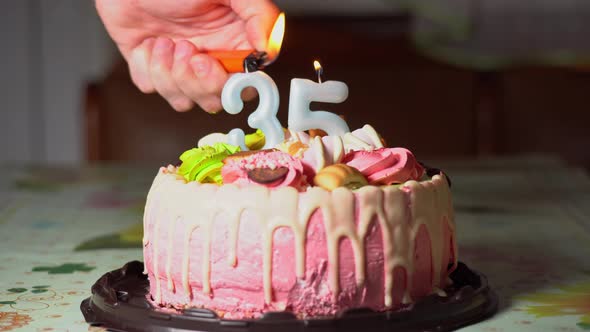 Lighting candles on a birthday cake. 35th birthday. Birth cake with a burning birth candle. Happy alt