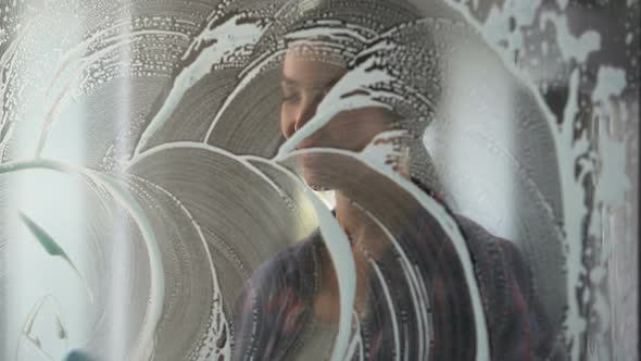 Lady Washing Windows and Removing Stains Using Special Substances and Tools alt