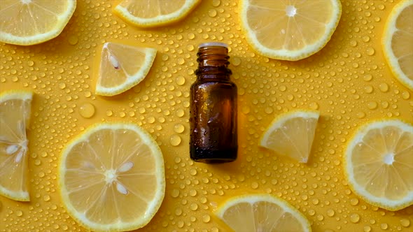 Lemon Essential Oil on a Yellow Background with Water Drops alt