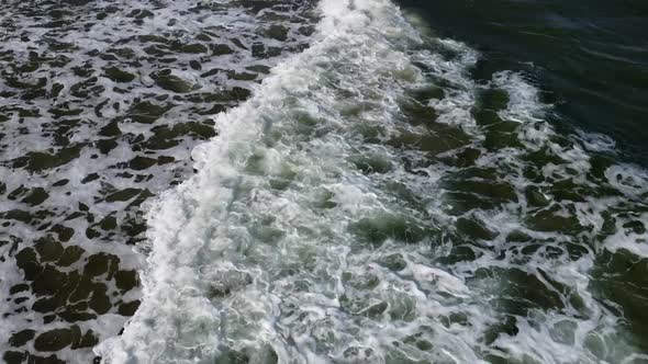 Aerial Drone View Flight Over Sea Waves That Roll Onto Sandy Shore alt