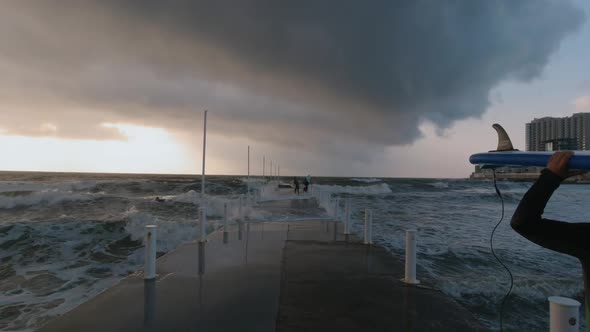 Surfers on the Pier During a Storm, Large Waves Break Into Spray, Odessa Ukraine Summer 2020