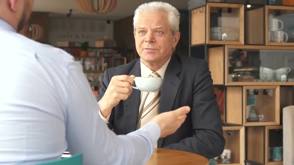 Senior Businessman Listens To His Partner