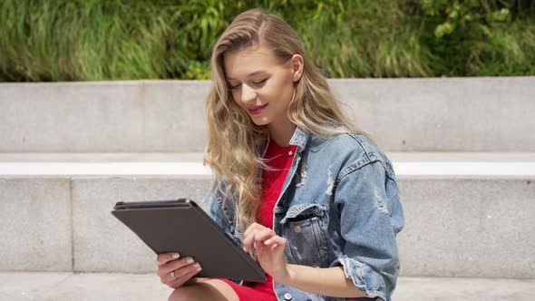 Young Woman Using Tablet on Street