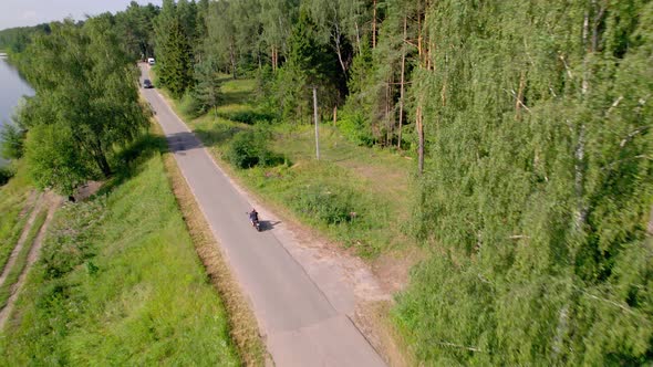 A Young Man Rides a Motorcycle Outside the City