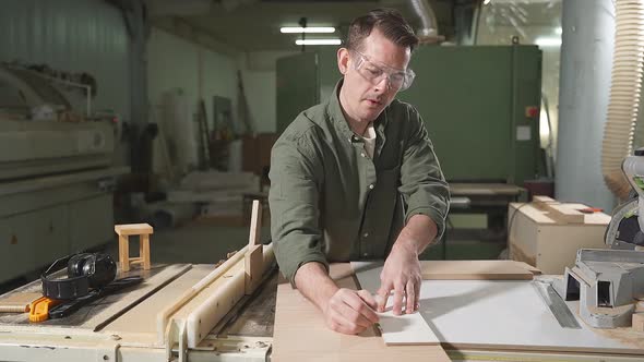 Male Carpenter in Green Shirt Wearing Safety Goggles for Woodworking
