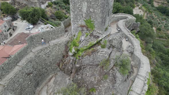 Medieval tower of Sortelha castle with Portuguese flag on top. Aerial tilt up reveal