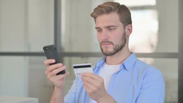 Portrait of Creative Man Making Online Payment on Smartphone alt