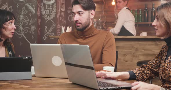 Young Freelance Entrepreneur Receiving Advice From His Female Colleagues alt