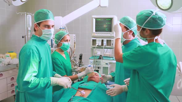 Group of surgeon operating an unconscious patient in an operating theater alt