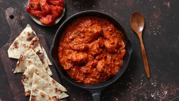 Traditional Indian Chicken Tikka Masala Spicy Curry Meat Food in Cast Iron Pan alt