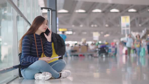 Young female traveler use smartphone calling while waiting someone 