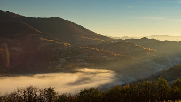 Sunset in Highland and Evening Fog Fills Valley in Autumn alt