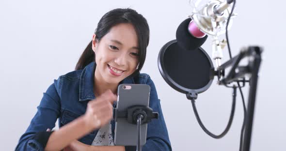 Young woman chatting on cellphone with live stream  alt