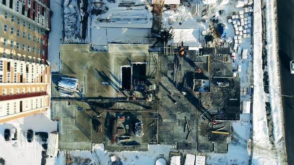 View From Above of a Building in Progress and Workers at Its Top alt
