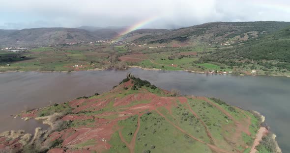 Flying Over a Red Mountain Along Lake Salagou Reveals the Rainbow in the Back