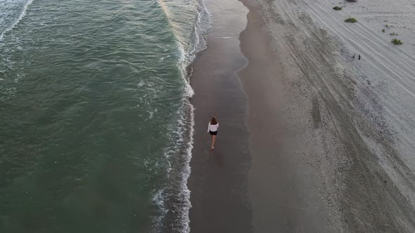 Beautiful Barefoot Woman Walking Along Deserted Beach