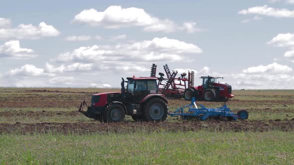 Tractor Cuts Furrows in Farm Field for Sowing Farm Tractor with Rotary Harrow Plow Preparing Land alt