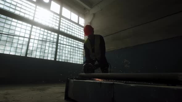 Construction Worker Cuts Steel with a Circular Saw Construction Worker's Feet Flying Sparks From a alt