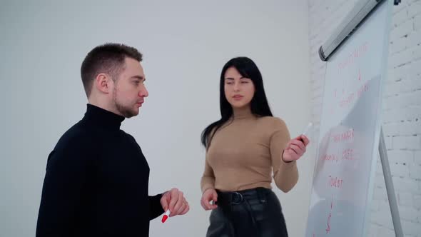 Young woman asks man about new project. Beautiful female listens the business partner. Young man ans alt