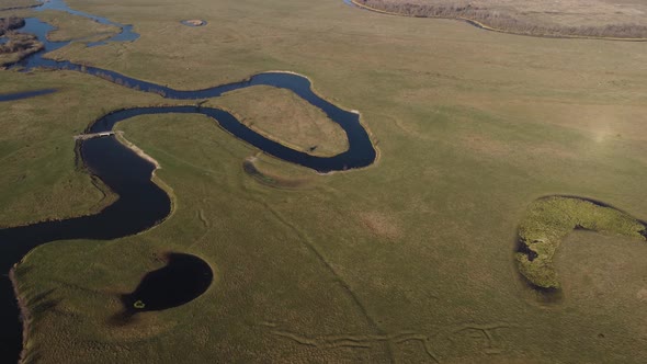 aerial view of a beautiful winding river flows among the fields, which flows picturesquely, 