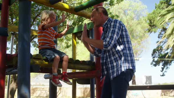 Father and son having fun at playground 4k alt