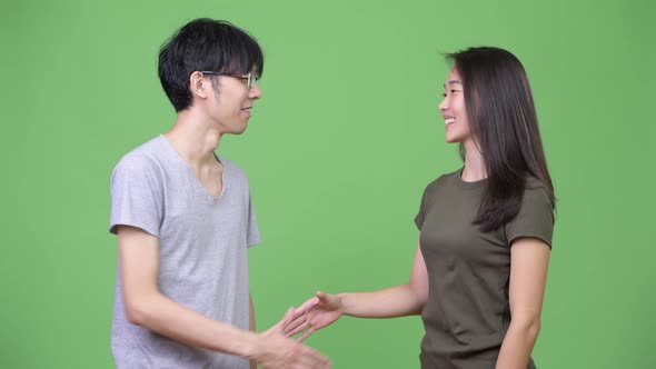 Young Asian Couple Shaking Hands