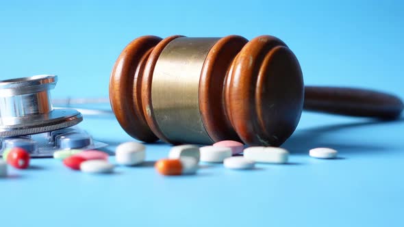 Top View of Gavel Stethoscope and Pills on White Background alt