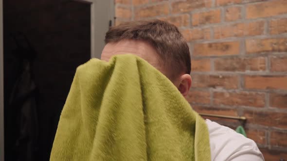 Man Wipes His Face Towel