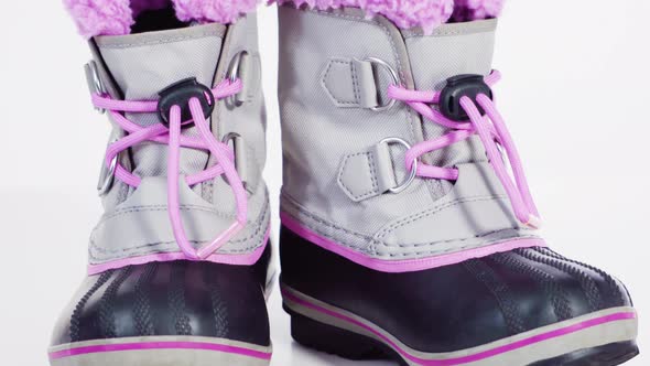 Little girl pink and gray warm and waterproof winter boots on a white background alt