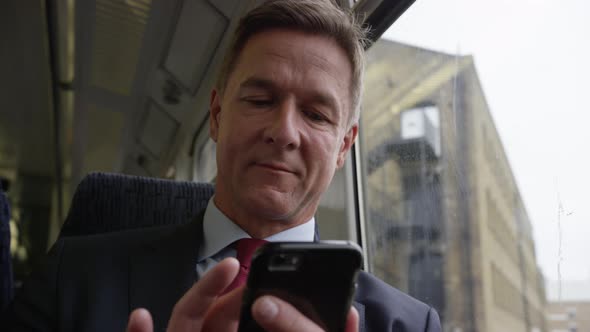 Commuter on his way to work looking at smart phone