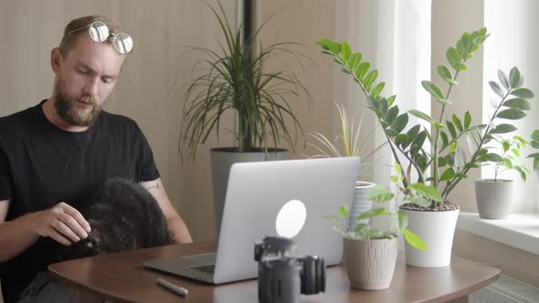 A Man with a Cat Sitting at the Computer