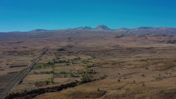 Aerial Drone Shot of Fields and Car Road on Background of Ararat alt