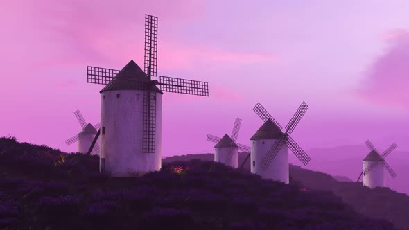 Multiple white, classic spanish windmills in the field during beautiful sunset.